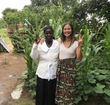 Photo of Maia Sparkman with student in front of trees